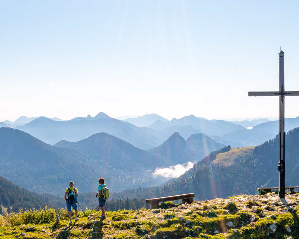 Zwei Wanderer am Gipfel des Seekarkreuz beim Sonnenaufgang